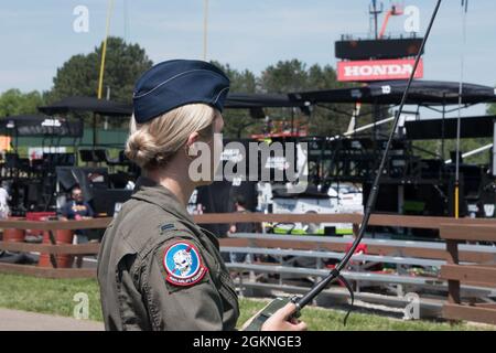 Primo tenente Samanda McGiffin, un membro del 164esimo Squadrone Airlift alla 179esima Ala Airlift, tiene una radio per comunicare con l'equipaggio a bordo di un C-130 al Mid-Ohio Sports Car Course il 5 giugno 2021. La 179esima Ala Airlift è stata richiesta da Mid-Ohio di volare un C-130 sopra la pista durante il National Anthem. Foto Stock