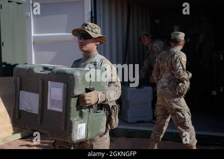 I soldati del 131st Field Hospital disimballano un contenitore di carico a Camp Old Ironsides, Fort Bliss, Texas, 5 giugno 2021. Nell'ambito dell'operazione sul campo Guardian Readiness, i soldati di Guardian Knight si sono alzati in piedi in un ambiente austero. Foto Stock