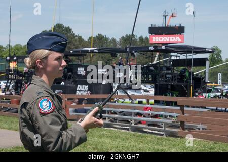 Primo tenente Samanda McGiffin, un membro del 164esimo Squadrone Airlift alla 179esima Ala Airlift, tiene una radio per comunicare con l'equipaggio a bordo di un C-130 al Mid-Ohio Sports Car Course il 5 giugno 2021. La 179esima Ala Airlift è stata richiesta da Mid-Ohio di volare un C-130 sopra la pista durante il National Anthem. Foto Stock