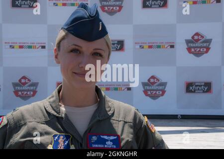 Il primo tenente Samanda McGiffin, un membro del 164esimo Squadrone Airlift alla 179esima Ala Airlift, si pone di fronte al palco principale al Mid-Ohio Sports Car Course il 5 giugno 2021. McGriffin ha servito come controllo di terra durante il volo sopra e ha comunicato con l'equipaggio nell'aereo per temporizzare il volo sopra con l'esecuzione dell'inno nazionale. Foto Stock