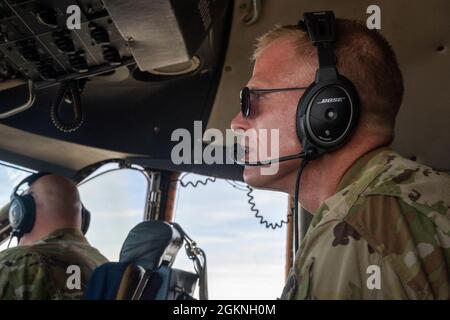 John Habbestad, 9° comandante dello Squadrone dell'Airlift, osserva lo spazio aereo circostante dal sedile di salto durante un volo di addestramento di routine su una C-5M Super Galaxy sopra la California, 5 giugno 2021. Durante un major Command Service Tail Trainer, i piloti e gli ingegneri di volo sono stati in grado di volare sulla costa occidentale utilizzando regole visive di volo. Ciò richiede che i membri dell'equipaggio utilizzino riferimenti di terra per volare, esercitando differenti insiemi di abilità non spesso utilizzati nelle operazioni quotidiane. Foto Stock