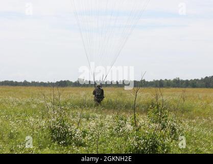 Un paratrooper della Riserva dell'Esercito degli Stati Uniti con il comando degli Affari civili e delle operazioni psicologiche dell'Esercito degli Stati Uniti (Airborne) naviga verso un atterraggio durante le operazioni non tattiche di trasporto aereo alla zona di goccia di Saint Mere Eglise, Fort Bragg, N.C., 5 giugno 2021. USACAPOC(A) Jumpmasters ha lavorato con il Capt. Ignacio Rios, un Jumpmaster cileno assegnato al 1° gruppo speciale di addestramento di guerra(A), il centro e la scuola speciali di guerra dell'esercito degli Stati Uniti John F. Kennedy Foto Stock