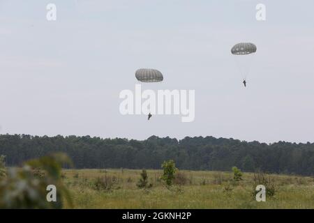 I paracadutisti della U.S. Army Reserve con il comando US Army Civil Affairs and Psychological Operations Command (Airborne) si dirigono verso un atterraggio durante operazioni non tattiche di volo a Saint Mere Eglise Drop zone, Fort Bragg, N.C., 5 giugno 2021. USACAPOC(A) Jumpmasters ha lavorato con il Capt. Ignacio Rios, un Jumpmaster cileno assegnato al 1° gruppo speciale di addestramento di guerra(A), il centro e la scuola speciali di guerra dell'esercito degli Stati Uniti John F. Kennedy Foto Stock