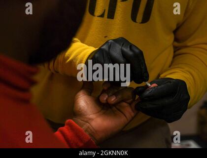 ATLANTIC OCEAN (07 GIUGNO 2021) Chief Aviation Boatswain’s Mate (Aircraft Handling) Brian Abeyta conduce un test del tipo di sangue durante un’esercitazione a piedi sulla banca del sangue a bordo della Expeditionary Sea base USS Hershel “Woody” Williams (ESB 4) nell’Oceano Atlantico, 07 giugno 2021. Hershel “Woody” Williams è in fase di dispiegamento programmato nell'area della Sesta flotta degli Stati Uniti di operazioni a sostegno degli interessi e della sicurezza nazionali degli Stati Uniti in Europa e Africa. Foto Stock