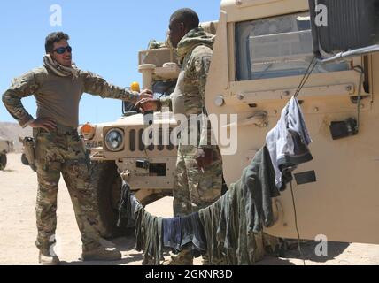 Chief Warrant Officer 3 Tony Imbastato e Sgt. Michael Clark, entrambi con la 155a squadra di combattimento delle brigate corazzate, la Guardia Nazionale dell'Esercito del Mississippi, conversarono mentre asciugavano la loro lavanderia tra le operazioni di addestramento al National Training Center di Fort Irwin, California, 8 giugno 2021. Il 155esimo ABCT è al NTC per mantenere la disponibilità a rispondere alle esigenze della nazione al momento opportuno. Foto Stock