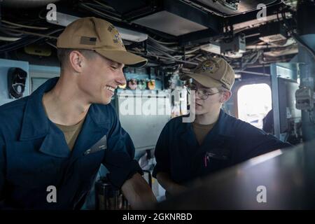 MAR BALTICO (8 giugno 2021) il compagno di Boatswain Seaman Nathan Hale, a destra, da Sandy, Oreg., dà addestramento al timone a Seaman Eric Bauman, da Sauk City, Wisc., sul ponte del cacciatorpediniere missile guidato di classe Arleigh Burke USS Roosevelt (DDG 80) durante il BALTOPS 50, 6 giugno 2021. Il cinquantesimo BALTOPS rappresenta un impegno continuo e costante per rafforzare l'interoperabilità nell'Alleanza e garantire la sicurezza marittima collettiva nel Mar Baltico. Foto Stock