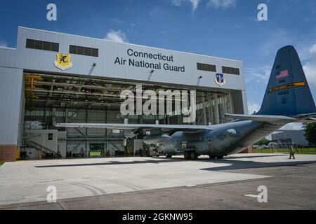 Gli airman del 103mo gruppo di manutenzione rimorchiano un aereo C-130H Hercules nella cella a combustibile e nell'hangar di controllo della corrosione alla base della Guardia Nazionale dell'aria di Bradley, Granby orientale, Connecticut, 8 giugno 2021. La struttura consente agli addetti alla manutenzione di eseguire le attività di manutenzione dei sistemi di alimentazione del combustibile e i lavaggi degli aeromobili, che sono fondamentali per mantenere la predisposizione della flotta C-130H Hercules della 103a Airlift Wing. Foto Stock