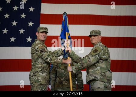 John Gallemore, ottavo comandante dell'ala dei combattenti, presenta il guidon cerimoniale al Colon Todd Wydra durante l'ottavo cambio di comando del gruppo di manutenzione alla base aerea di Kunsan, Repubblica di Corea, 8 giugno 2021. Wydra, l'ottavo comandante MXG entrante, assunse il comando dell'ottavo MXG dal comandante uscente, col. Daniel Cornelius. Foto Stock