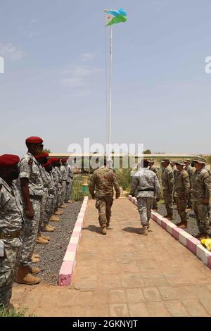 Adam Greene, comandante della seconda Brigata di assistenza delle forze di sicurezza, Mohamed Assoweh, comandante del rapimento di Battaglione Gibutiano (BIR), cammina fino al capitano Steven Kornegay, seconda Brigata di assistenza delle forze di sicurezza, per la sua promozione al BIR Compound a Gibuti, 9 giugno 2021. Il capitano Kornegay ha avuto una cerimonia di promozione combinata con i soldati della BIR Gibutiana. Foto Stock