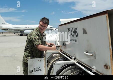 210609-N-SF984-0117 SAN DIEGO (giugno 9,2021) Aviation Electrician's Mate 3rd Class Simon Town, assegnato ai 'conquistadors' di Fleet Logistics Squadron (VR) 57, utilizza un camion elettrico per condurre la manutenzione di uno dei C-40 Clippers dello squadrone. VR-57 è uno squadrone della Navy Reserve che fornisce supporto logistico in tutta la flotta. Foto Stock