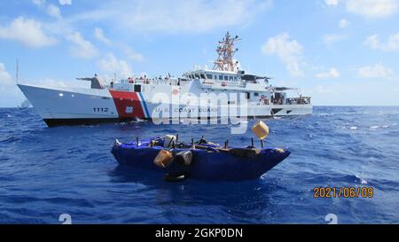 Un'imbarcazione migrante inadatta si trova di fronte alla Cutter della Guardia Costiera Isaac Mayo, 27 miglia a sud di Long Key, Florida, 9 giugno 2021. Un team di forze dell'ordine del tagliatore ha interdetto 16 migranti cubani dall'imbarcazione. Foto Stock