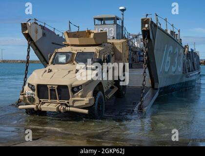 WHITE BEACH, Giappone (Jun. 10, 2021) A III Marine Expeditionary Force i veicoli tattici leggeri congiunti si imbarcano su un'utility di imbarcazioni di atterraggio al Commander, Fleet Activities Okinawa White Beach Naval Facility, Okinawa, Giappone Jun. 10, 2021. Nave d'assalto anfibio di classe americana USS America (LHA 6) è ormeggiata lato molo sullo sfondo. Foto Stock