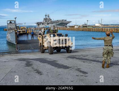 WHITE BEACH, Giappone (Jun. 10, 2021) Seaman Marla Sandoval, di Des Moines, Ia. e assegnato alla Naval Beach Unit 7, lavora con il personale di servizio dell'imbarcazione di atterraggio per dirigere una III forza di spedizione marina veicoli tattici leggeri congiunti sulla LCU al Commander, Fleet Activities Okinawa White Beach Naval Facility, Okinawa, Giappone Jun. 10, 2021. Foto Stock