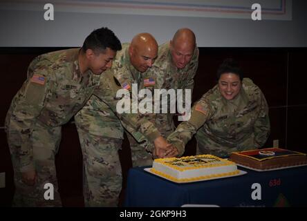 In tradizione con il taglio di una torta di compleanno dell'esercito, il più giovane Soldier Sgt. Jonathan Avila (all'estrema sinistra) e il più antico staff soldato Sgt. Dellarosa Kinlaw (all'estrema destra) insieme a Major Gen. Alberto Rosende (al centro a sinistra) e Command Sgt. Il Major Patrick Mckie (al centro a destra) ha tagliato la torta di compleanno dell'esercito all'unisono usando una replica di un coltello dell'esercito con un'iscrizione di 'sangue e fuoco' sulla sua lama, 11 giugno 2021. I soldati celebrano per la prima volta il patrimonio della 63° RD con attività, una cerimonia e musica della 191a Army Band out of Dublin, California. Foto Stock