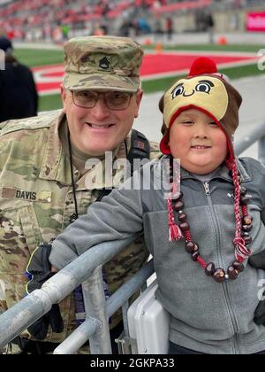 Personale Sgt. George Davis e suo figlio, Park Davis, si riuniscono per scattare una foto alla partita di calcio militare all'Ohio state University. Davis è attualmente dispiegato in Europa a sostegno dell'operazione Atlantic Resolve. Park augura a suo padre un felice giorno del Padre. "Sono orgoglioso di mio padre. È in campo militare e fa soldi e può comprare giocattoli; sta facendo in modo che il mondo sia sicuro”. Foto Stock