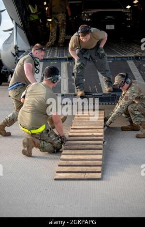 I facchini aerei del 123o Gruppo di Risposta di emergenza della Guardia Nazionale aerea del Kentucky si preparano a scaricare il carico da un aeromobile a Volk Field, Wis., 11 giugno 2021, come parte di una Joint Task Force-Port Opening operazione di supporto Lone Oak. L'aereo, dalla Alaska Air National Guard, ha consegnato camion, forniture e personale che stavano partecipando all'esercizio Patriot North 21 qui. Foto Stock