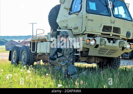 Pvt. Eric Sicoli, ingegnere di costruzioni orizzontali con la 357a Engineer Company, 412th Theatre Engineer Command, si inginocchia in posizione difensiva durante una missione di recupero veicoli come parte dell'esercizio per il Guerriero della 86tgh Training Division (WAREX) 86-21-02 il 11 giugno 2021, a Fort McCoy, Wis. Il WAREX fornisce alle unità della riserva dell'esercito degli Stati Uniti scenari realistici di addestramento durante le loro due settimane di addestramento annuale. Foto Stock