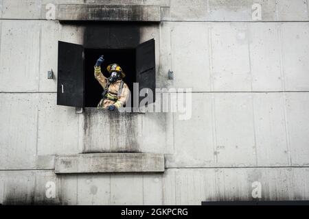 Un vigile del fuoco con il 193a Special Operations Civil Engineer Squadron, Pennsylvania Air National Guard, segnala fino ai vigili del fuoco che operano il loro veicolo 12 giugno 2021 alla York County Fire School di York, Pennsylvania. I vigili del fuoco della Pennsylvania Air e della Guardia Armata hanno lavorato insieme per condurre vari scenari di addestramento antincendio dal vivo. Foto Stock