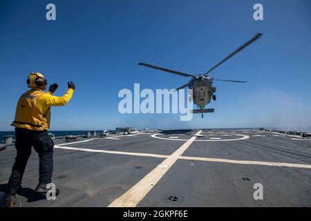 MAR BALTICO (13 giugno 2021) Boatswain’s Mate 2a Classe Calvin Goon dirige un elicottero MH-60S Seahawk assegnato ai “Ghostriders” di Helicopter Sea Combat Squadron (HSC) 28 mentre si prepara ad atterrare sul ponte di volo del cacciatorpediniere missilistico guidato di classe Arleigh Burke USS Roosevelt (DDG 80) durante il BALTOPS 50, Giugno 13, 2021. Il cinquantesimo BALTOPS rappresenta un impegno continuo e costante per rafforzare l'interoperabilità nell'Alleanza e garantire la sicurezza marittima collettiva nel Mar Baltico. Foto Stock