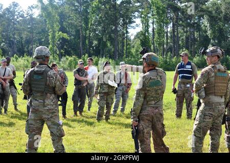 I membri del 53mo Squadrone di controllo del traffico aereo ricevono un riepilogo dal Wing Inspection Team a seguito di un attacco simulato durante l'esercizio Fast Money tenuto a Eastman, Georgia, 13 giugno 2021. Il 53esimo ATCS con la 461a Ala di controllo dell'aria dalla base dell'aeronautica di Robins, Georgia, ha eseguito il denaro veloce per aumentare le loro abilità di prontezza, che includeva tattiche difensive e protettive in risposta agli attacchi convenzionali e alle minacce chimiche, biologiche, radiologiche e nucleari. Foto Stock