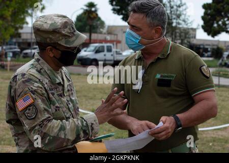 U.S. Army Reserve Sgt. Il Major Forrest McKinley, alto funzionario non commissionato del 2500esimo distaccamento di collegamento digitale, 7° comando di supporto della Missione, a sinistra, sviluppa il registro di accesso di base per i suoi soldati con l'Esercito Italiano Sgt. Giovanni di Maio durante l'esercizio DEFENDER-Europe 21, a Capua, Italia, 10 giugno 2021. Il 2500° DLD ha fornito capacità di collegamento tra il V corpo dell'Esercito USA e la Divisione Acqui dell'Esercito Italiano. Foto Stock