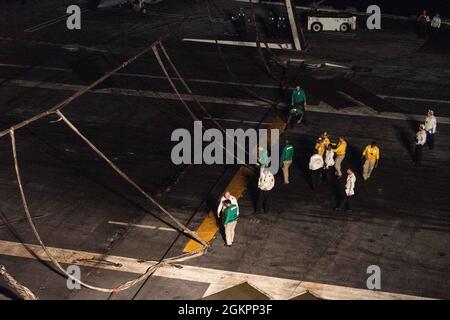 210615-N-ML137-2053 SOUTH CHINA SEA (15 giugno 2021) i marinai hanno allestito una barricata di aerei durante una perforazione generale sul ponte di volo dell'unica portaerei della Marina statunitense USS Ronald Reagan (CVN 76). Ronald Reagan, la nave ammiraglia del Carrier Strike Group 5, fornisce una forza pronta per i combattimenti che protegge e difende gli Stati Uniti, nonché gli interessi marittimi collettivi dei suoi alleati e partner nella regione Indo-Pacific. Foto Stock