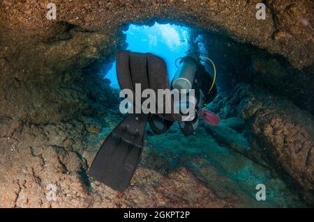 I subacquei esplorare grotte naturali e rocce nel mare Mediterraneo al largo della costa di Larnaca, Cipro, Foto Stock