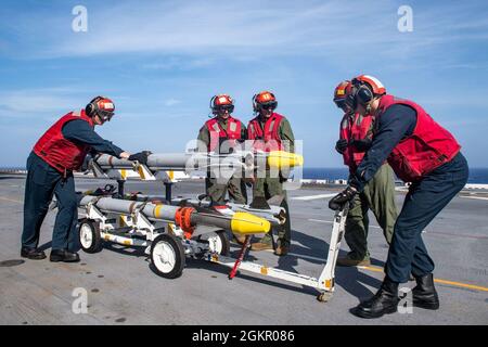 MARINAI DELLE FILIPPINE (16 giugno 2021) assegnati alla nave d'assalto anfibio dispiegata in avanti USS America (LHA 6) e Marines assegnati alla 31a unità di spedizione marittima (MEU) sul ponte di volo della nave. L'America, nave principale dell'America Amphibious Ready Group, insieme al 31° MEU, sta operando nell'area operativa della 7a flotta statunitense per migliorare l'interoperabilità con alleati e partner e servire come forza di risposta pronta a difendere la pace e la stabilità nella regione dell'Indo-Pacifico. Foto Stock