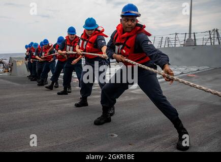 210617-N-QI061-0045 OCEANO ATLANTICO (17 giugno 2021) i marinai salgono lungo la linea a bordo del cacciatorpediniere missilistico guidato di classe Arleigh Burke USS Paul Ignatius (DDG 117) durante un'evoluzione del rifornimento in mare, 17 giugno 2021. Paul Ignatius opera nell'Oceano Atlantico a sostegno delle operazioni navali per mantenere la stabilità e la sicurezza marittima al fine di garantire l'accesso, scoraggiare l'aggressione e difendere gli interessi statunitensi, alleati e partner. Foto Stock