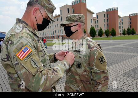 Michael R. Kaloostian, comandante della seconda Brigata del segnale teatrale, spilla la Meritorious Service Medal il L. John L. Harrell, comandante uscente della 509a Battaglione del segnale strategico, durante la cerimonia del cambio di comando sotto la condizione di prevenzione di Covid-19 a Caserma del DIN, Vicenza, Italia 17 giugno 2021. Foto Stock