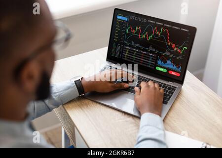 Uomo d'affari nero che usa il laptop, il commercio in linea, la vista ad alta angolazione Foto Stock