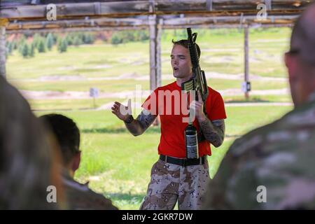 U.S. Navy Petty Officer 2a classe Nicholas Wood, con l'Expeditionary Medical Facility, Jacksonville, FL (EMF-Jax), briefing U.S. Army National Guardsmen con la Forward Support Company, 109th Engineer Battaglione, prima di un esercizio "Perform immediate Lifesaving Measures" per Golden Coyote al West Camp Rapid City, S.D., giugno 17, 2021. Golden Coyote è un esercizio di forza congiunta progettato per sviluppare le abilità tattiche di supporto ai combattimenti dei membri del servizio attraverso eventi basati su scenari. Foto Stock