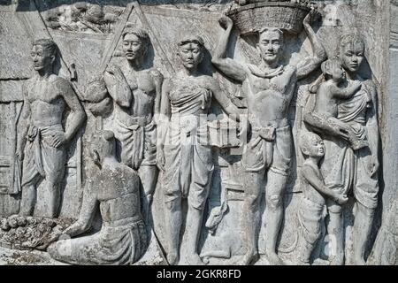 Un fregio nel Parco di Santichaiprakarn, Banglamphu, Bangkok, Thailandia, raffigurante la vita della classe operaia del vecchio Siam (l'ex nome della Thailandia) Foto Stock