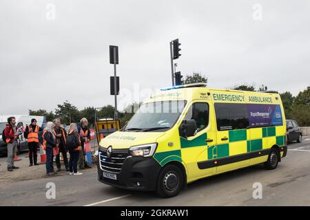 Enfield, Regno Unito. 15 settembre 2021. Una delle due ambulanze di emergenza passa dopo che gli attivisti climatici britannici insulati si sono spostati da una strada di sicurezza dalla M25 allo svincolo 25 che stavano bloccando come parte di una campagna volta a spingere il governo britannico a fare un cambiamento legislativo significativo per iniziare a ridurre le emissioni. Gli attivisti, che hanno scritto al primo ministro Boris Johnson il 13 agosto, chiedono che il governo prometta immediatamente sia di finanziare e garantire l'isolamento di tutti gli alloggi sociali in Gran Bretagna entro il 2025 e di produrre entro quattro mesi un piano nazionale giuridicamente vincolante Foto Stock