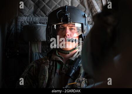 Un soldato assegnato alla Bravo Company, 1° Battaglione, 168° Regiment Aviazione, 40th Combat Aviation Brigade, siede su un CH-47 Chinook a Camp Buehring, Kuwait, 20 giugno 2021. Durante il volo, gli agenti meteorologici del personale assegnati al 22 d Squadron Expeditionary Weather Support hanno avuto l'opportunità di volare con un aeromobile a cui forniscono supporto. Foto Stock