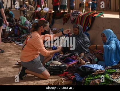 Un membro del servizio statunitense assegnato alla Nigerien Air base 201 naviga attraverso l'inventario di un fornitore durante un bazaar il 20 giugno 2021 alla Air base 201, Niger. I membri della base aerea 201 hanno iniettato con successo più di 4.2 milioni di franchi CFA dell'Africa occidentale, che sono circa 14 mila dollari nell'economia locale. Foto Stock
