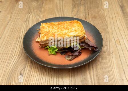 Porzione rettangolare di lasagna con diversi strati separati di fogli di carne e pasta e la parte superiore con beshamel e gratin Foto Stock