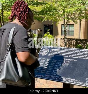 Un membro della famiglia legge i nomi dei soldati che sono onorati nel Fort Campbell Soldier Recovery Unit Warrior Memorial Garden. Per i soldati che combattono contro una malattia che finisce la vita, o malattia terminale, l’attenzione della SRU comprende il miglioramento della qualità della vita per il soldato, l’alleviamento della sofferenza fisica, emotiva e spirituale e il sostegno ai loro cari in un periodo molto difficile. Foto Stock