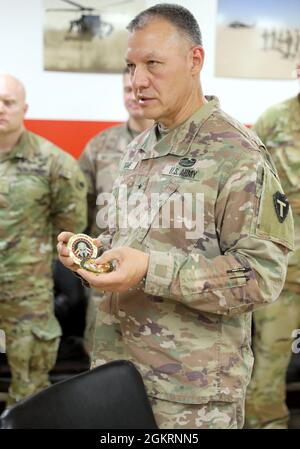 Briga. Il Gen. Michael Adame, il 36esimo vice comandante generale della Divisione di fanteria - supporto, spiega il significato che ha alla base della sua moneta di unità a pochi destinatari alla conclusione di un briefing a Camp Buehring, Kuwait. Foto Stock