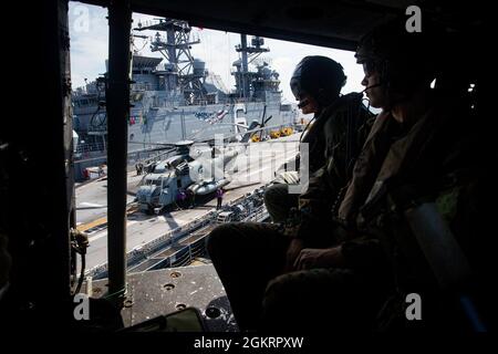 I Marines USA con Force Reconnaissance Platoon, 31st Marine Expeditionary Unit (MEU), osservano la nave d'assalto anfibio USS America (LHA 6) mentre si dirigono verso la USS Germantown (LSD 42) per condurre un esercizio di addestramento di operazione d'interdizione marittima (MIO) nel Mare delle Filippine, 24 giugno 2021. IL MIO consisteva in Force Reconnaissance Marines che si protraripano rapidamente verso la USS Germantown ed eseguiva uno scenario di ricerca e sequestro con il supporto della Battaglione Landing Team 3/5 come elemento di sicurezza. Il 31 MEU è attivo a bordo di navi dell'America Amphibious Ready Group nella 7° area della flotta o Foto Stock