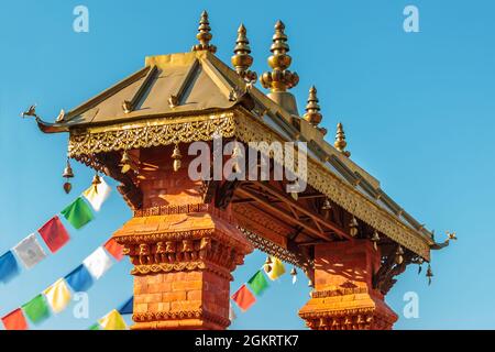 Porta d'ingresso ornamentale nepalese di un tempio con bandiere colorate Foto Stock
