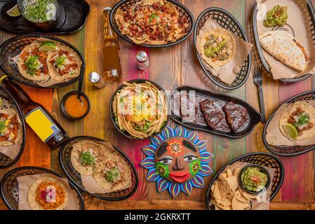 Immagine vista dall'alto di un set di piatti messicani, insalate di mango, quesadillas, cocinita pibil guacamole, tacos al pastor, nachos con peperoncino e formaggio, borra Foto Stock