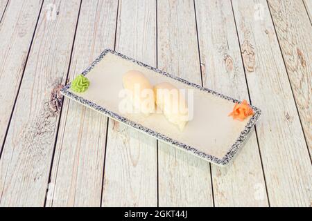 vassoio con nigiri di pesce farfalla con wasabi e ginseng su tavola bianca in legno Foto Stock