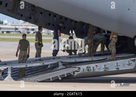 Una combinazione di personale dell'Aeronautica militare della 315a Ala Airlift, membri della Guardia Costiera degli Stati Uniti, così come agenti dell'FBI e dell'ATF carico attrezzature e veicoli aborrano un C-17 dalla 315a Ala Airlift il 25 giugno 2021. Exercise Patriot Palm è un'esercitazione congiunta di emergenza e risposta alle calamità naturali coordinata dalla Air Force Reserve, progettata per integrare i soccorritori delle agenzie federali, statali e locali e militari fornendo una rapida formazione di risposta. Foto Stock