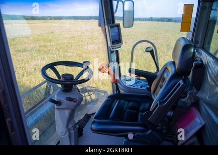 Vista del campo di mais dalla cabina di una mietitrebbia in una giornata di sole. Luogo di lavoro di un operatore della mietitrebbia. Foto Stock