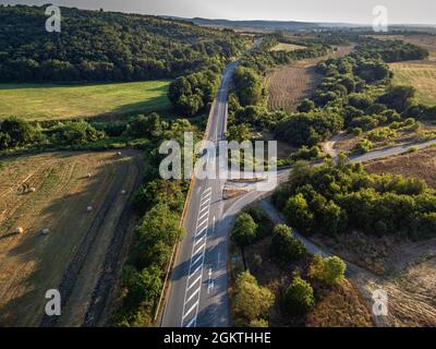 Strada che attraversa i terreni agricoli della Bulgaria orientale Foto Stock