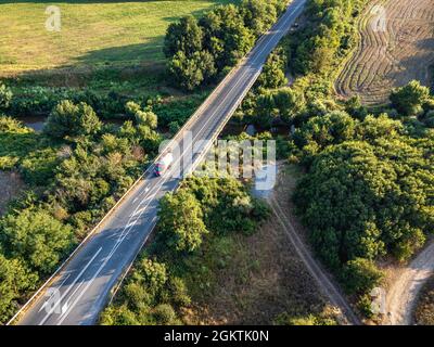 Strada che attraversa i terreni agricoli della Bulgaria orientale Foto Stock