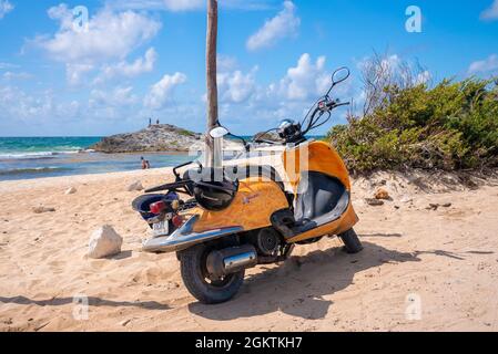 Scooter dal design giallo parcheggiato sulla spiaggia in una giornata di sole Foto Stock