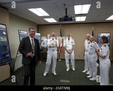 Chirurgo della Marina degli Stati Uniti Generale posteriore ADM. Bruce Gillingham (2° da sinistra) e Naval Medical Forces Pacific Commander posteriore ADM. Tim Weber (centro) condivide una risata con il Dr. David Fothergill (a sinistra), direttore scientifico del Naval Submarine Medical Research Laboratory Foto Stock