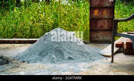 Mucchio piccolo di cemento e calcestruzzo in cantiere in un villaggio. Campagna India. Foto Stock